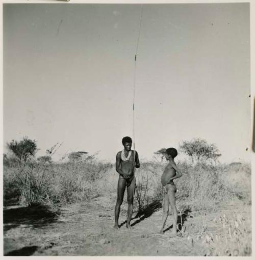 "Old Gau" holding a spring-hare hook, with a boy standing next to him