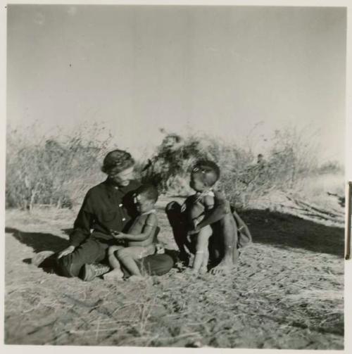 Gau sitting with Lorna Marshall, with /Qui sitting in Lorna's lap and Khuan//a leaning against Gau