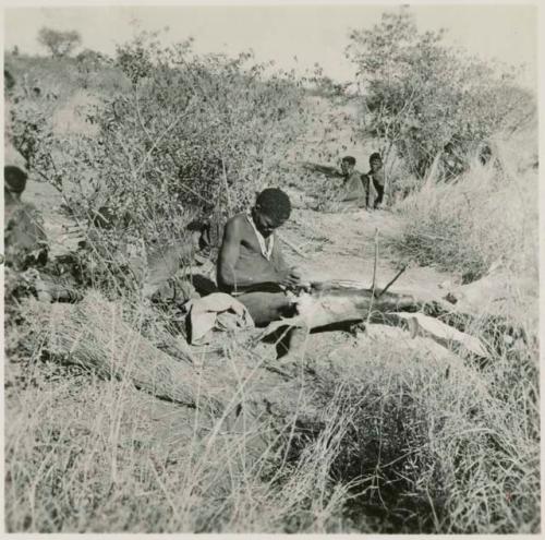 Man making a bag from a wild pig skin