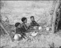 Three children sitting, eating mealies