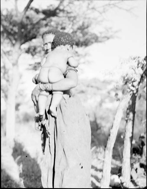 Woman standing and holding a baby (out of focus)