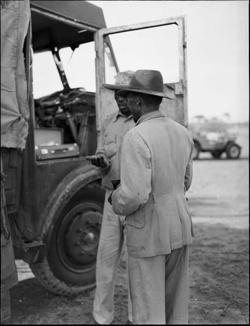 Driver of a WNLA (Witwatersrand Native Labor Association) truck giving something to Muremi