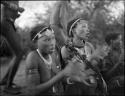 //Kushay (wife of "/Qui Navel") and another woman (probably daughter of Debe, headman of Band 24) singing and clapping for a curing dance, close-up