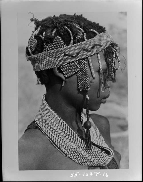 Profile of N≠isa showing an earring of a few copper beads