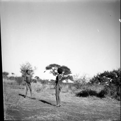 Two boys tossing a djani (helicopter toy / winged toy made from a hollow reed)