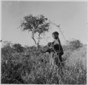 "Old /Gasa" standing, holding a wildebeest head