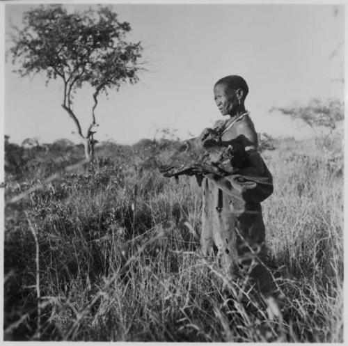 "Old /Gasa" standing, holding a wildebeest head