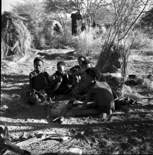 Group of people sitting, with skerms in the background