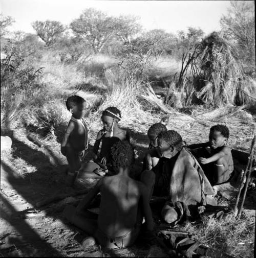 Group of people sitting, including Bau (daughter of /Ti!kay) and /Naoka (sister of /Goishay, mother of /Ti!kay's wives)