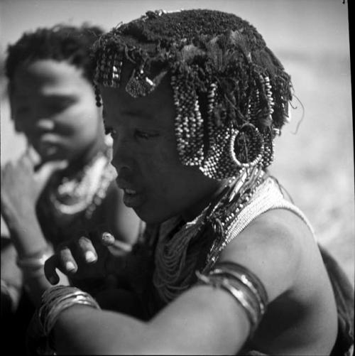 ≠Gisa (daughter of Khwo//o-/Gasa and ≠Gao) wearing hair ornaments, sitting with another girl