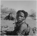 Girl sitting, with another person in the background