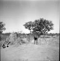 Child standing on an anthill, view from behind