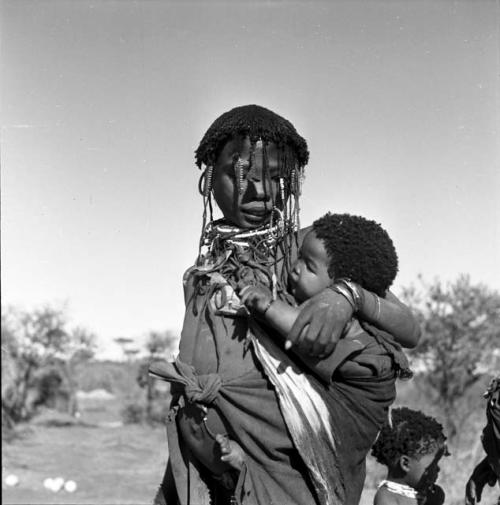 Woman carrying a baby in a kaross