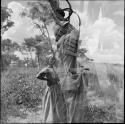 Woman wearing a long dress, standing with her hands on her hips (double exposure)