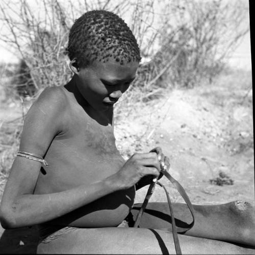 Gau's son holding a slingshot made from a piece of an old inner tube