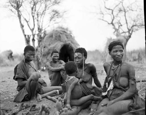 Group of people sitting, including !Ungka (sister of //Kushay), "/Qui Navel," //Kushay holding "Little ≠Gao," and //Khuga (daughter of "Gao Medicine," wife of Crooked /Qui)