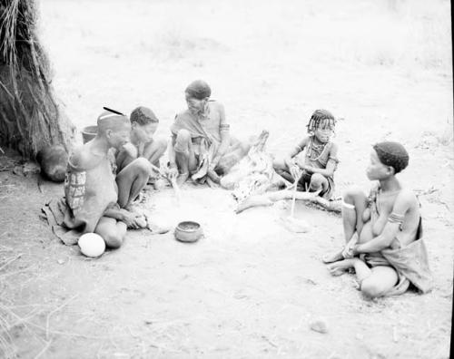 ≠Gao (brother of "Old Gau") sitting next to the ashes of a fire with his wife, Khwo//o-/Gasa (daughter of "Old /Gaishay"), their son, Gao, ≠Gisa, ≠Gisa's mother and Khuan//a (wife of //Ao and sister of Khwo//o-/Gasa)