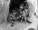 "Gao Helmet" sitting with two of his children in front of his skerm