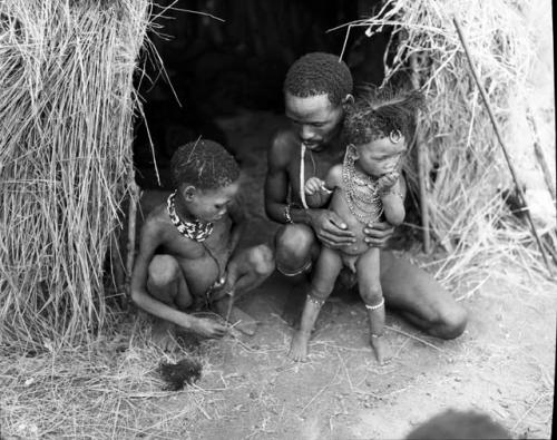 "Gao Helmet" sitting with two of his children in front of his skerm