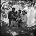 ≠Toma wearing Western clothing, handing tobacco to Venter, with John Marshall filming them