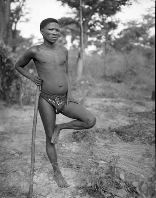 Man standing on one leg, leaning against his stick