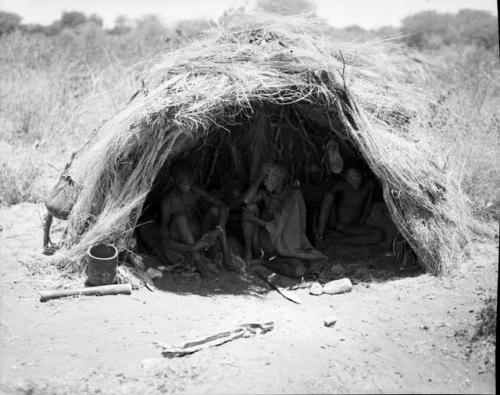 /Qui sitting inside a skerm with two other people