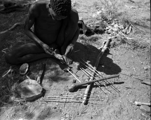 "Gao Medicine" applying poison to the shaft of an arrow with a stick, close-up