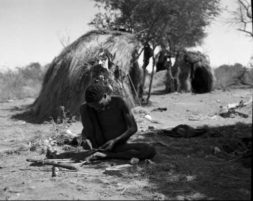 "Gao Medicine" applying poison to the shaft of an arrow with a stick, with skerms in the background