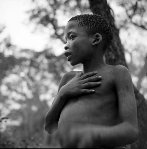 Boy talking, holding his hand on his chest