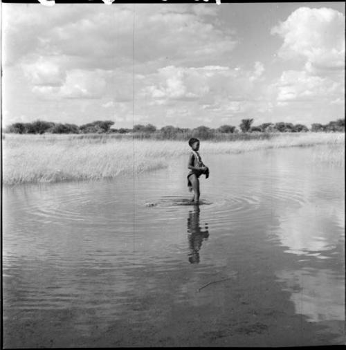 Girl standing in the water in a pan, distant view