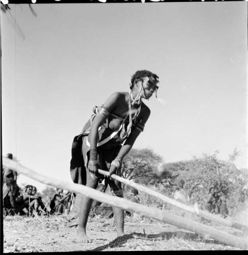 Woman beating mohengo with a pole