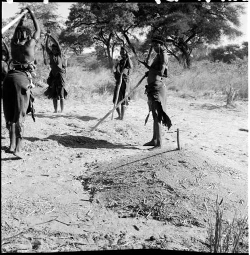 Four women standing in a circle, beating mohengo