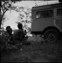 Men sitting on the ground next to the expedition Land Rover