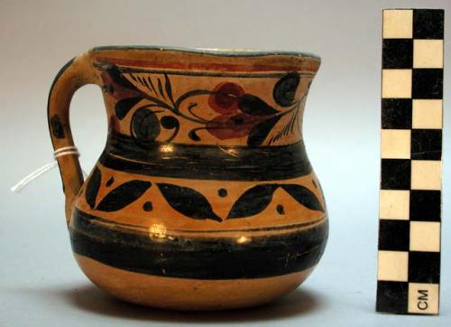 Small pitcher with pouring lip. blue and red floral bands of decoration