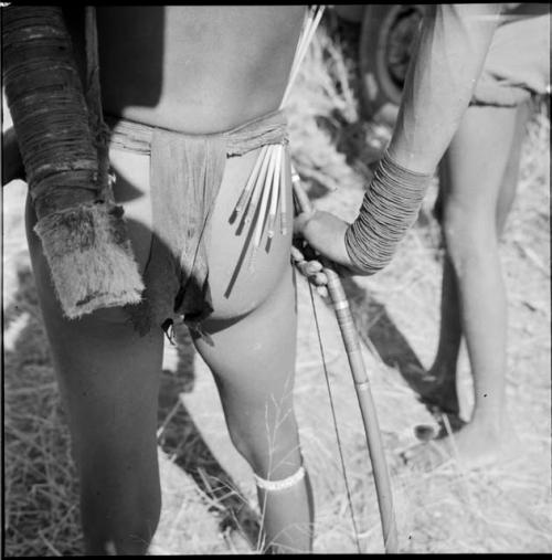 Hunter carrying a quiver and arrows in his belt, view from behind, close-up