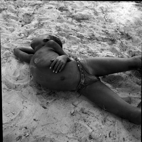 Boy lying on the sand, sleeping