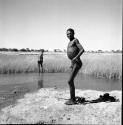 "Gao Medicine" standing at the edge of a pan after bathing, with another man standing in the distance behind him