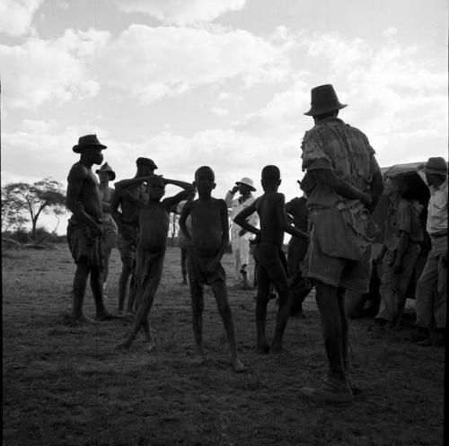 Group of men standing with John Marshall and two other expedition members next to the expedition Jeep