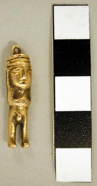 Small male figurine with hat; silver/gold alloy pendant with ring on top.