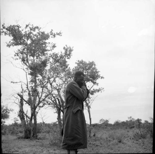 Man from Kubi standing, holding his hands to the side of his face