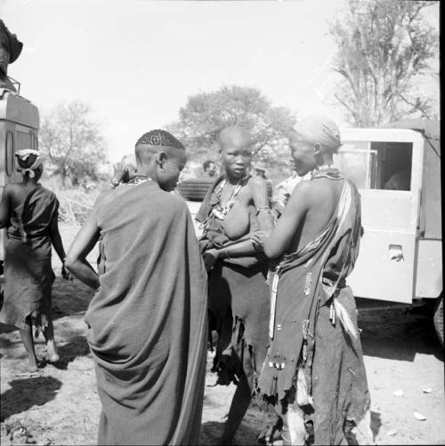 Three women standing near the expedition vehicles