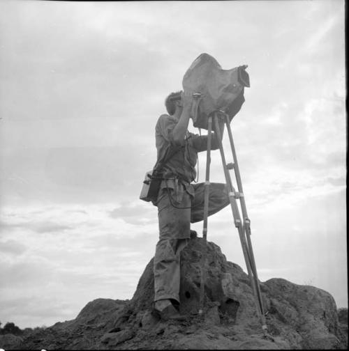 John Marshall filming on top of a termite mound