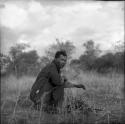 Wilhelm Camm squats next to a fire