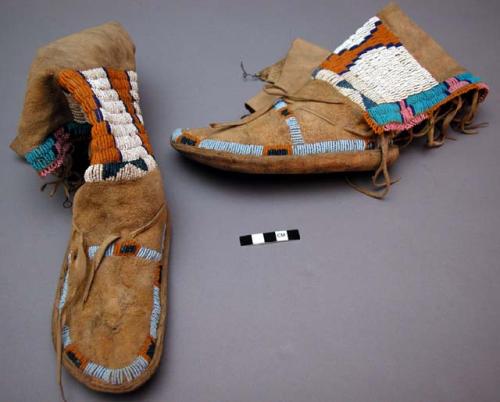 One pair of small moccasins. Long skin uppers with hard rawhide sole.