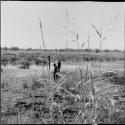 Three men standing in the veld, with a small pan in the background