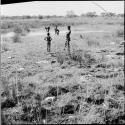 People standing in and next to a pan filled with water, distant view