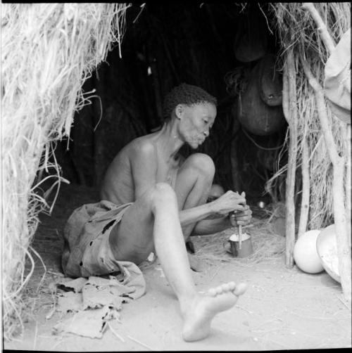 Woman sitting inside a skerm, adjusting a tool used for mixing