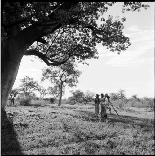 Two expedition members filming, distant view