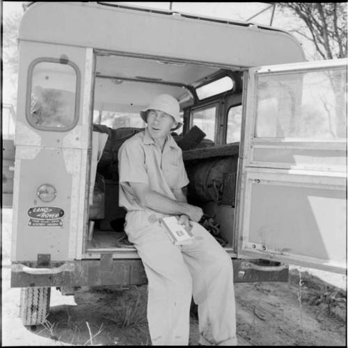 Robert Story sitting on the back of the expedition Land Rover