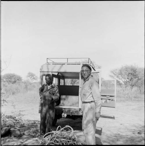 Charles Koch standing with another expedition member near the back of the Land Rover